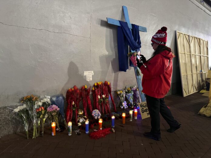 A Georgia football fan takes a photo of a memorial to victims of the deadly truck attack on Bourbon street after the area reopened, Thursday, Jan. 2, 2025, in New Orleans. (AP Photo/Jack Brook)