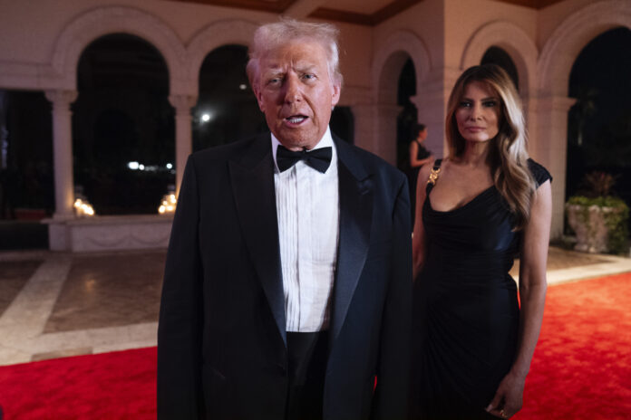 Melania Trump looks on as President-elect Donald Trump speaks to reporters before a New Year's Eve party at Mar-a-Lago, Tuesday, Dec. 31, 2024, in Palm Beach, Fla. (AP Photo/Evan Vucci)