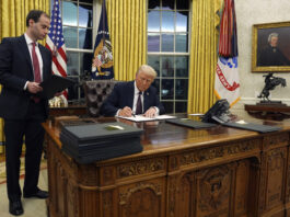 President Donald Trump signs an executive order withdrawing the U.S. from the World Health Organization in the Oval Office of the White House, Monday, Jan. 20, 2025, in Washington. (AP Photo/Evan Vucci)