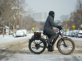 A cyclist navigates 13th Avenue after a winter storm plunged daytime high temperatures into the single digits and left up to six inches of snow in its wake Monday, Jan. 20, 2025, in Denver. (AP Photo/David Zalubowski)