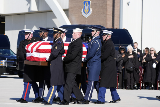 A joint forces military body bearer team moves flag-draped casket of former President Jimmy Carter to Special Air Mission 39 at Dobbins Air Reserve Base in Marietta, Ga., Tuesday, Jan. 7, 2025. Carter died Dec. 29 at the age of 100. (AP Photo/Alex Brandon, Pool)