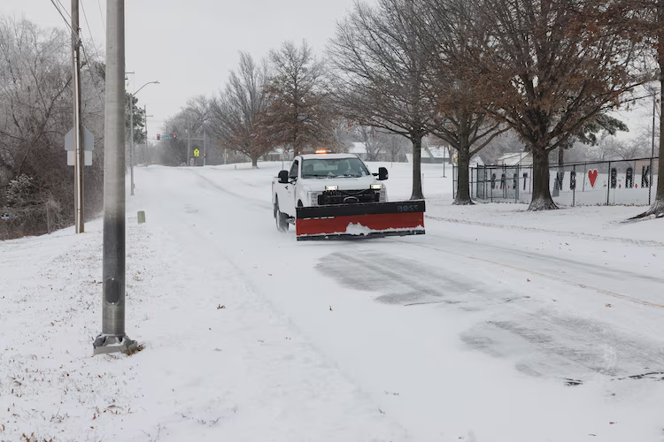 A county truck with a snowplow drives down a road in Shawnee, Kan., Jan. 5, 2024.
Chase Castor/Getty Images