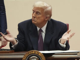 President Donald Trump gestures as he signs executive orders at an indoor Presidential Inauguration parade event in Washington, Monday, Jan. 20, 2025. (AP Photo/Matt Rourke)