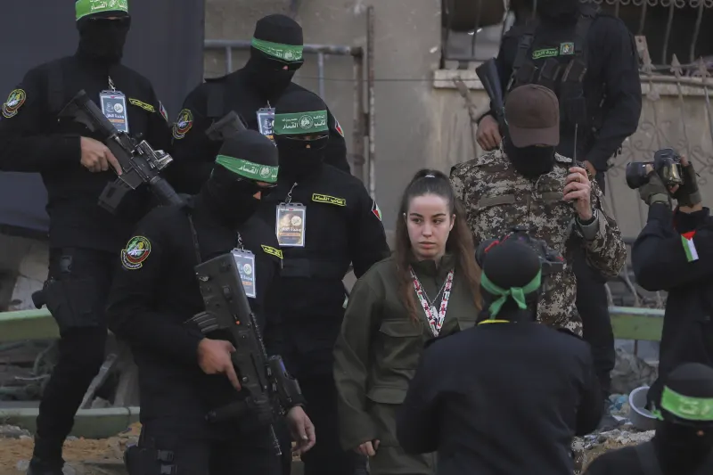 Israeli soldier Agam Berger walks next to masked Islamic Jihad militants as she is handed over to the Red Cross at the Jabalya refugee camp in Gaza City, Thursday Jan. 30, 2025.(AP Photo/Mohammed Hajjar)

