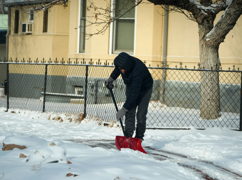 A man clears a walkway outside a Denver home on Monday amid temperatures in the single digits. David Zalubowski/AP