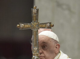 Pope Francis holds the cross as he presides over an Epiphany mass in St.Peter's Basilica, at the Vatican, Monday, Jan. 6, 2025. (AP Photo/Alessandra Tarantino)