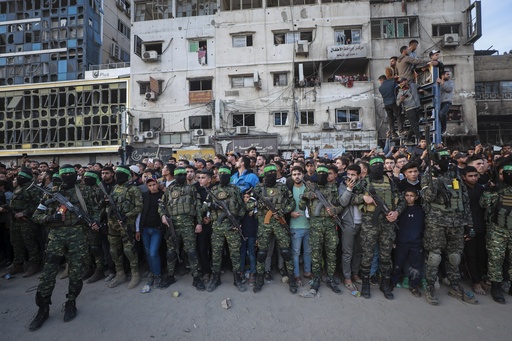 FILE - Fighters from the Qassam Brigades, the military wing of Hamas, control the crowd while Red Cross vehicles come to collect Israeli hostages to be released under a ceasefire agreement between Israel and Hamas, in Gaza City, Jan. 19, 2025. (AP Photo/Abed Hajjar, File)