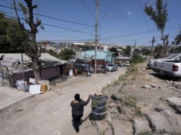 Martha Rosales walks back to her home where she houses Cuban migrants as they wait for an appointment to apply for asylum in the United States through the CBP One app Wednesday, May 22, 2024, in Tijuana, Mexico. (AP Photo/Gregory Bull)