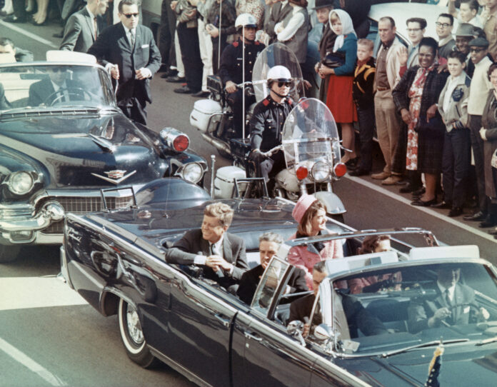 US President John F Kennedy, First Lady Jacqueline Kennedy, Texas Governor John Connally, and others smile at the crowds lining their motorcade route in Dallas, Texas, on November 22, 1963. Minutes later the President was assassinated as his car passed through Dealey Plaza.