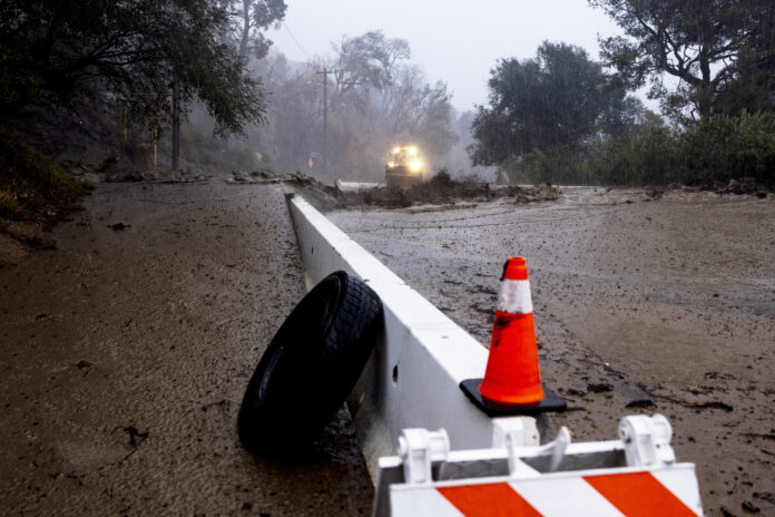 A road is covered in mud in the Eaton Fire zone during a storm Thursday, Feb. 13, 2025, in Altadena, Calif. (AP Photo/Etienne Laurent)