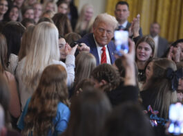 President Donald Trump hands a pen to Riley Gaines after signing an executive order barring transgender female athletes from competing in women's or girls' sporting events, in the East Room of the White House, Wednesday, Feb. 5, 2025, in Washington.(AP Photo/ Evan Vucci)