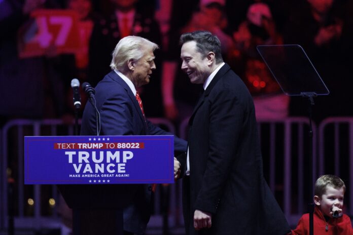 WASHINGTON, JANUARY 19: Tesla Founder Elon Musk walks on stage with his son, X, beside President-elect Donald Trump during a rally at Capital One Arena in Washington, on January 19, 2025. Trump held a rally downtown ahead of tomorrow's 60th Presidential Inauguration. (Photo by Tom Brenner for The Washington Post via Getty Images)