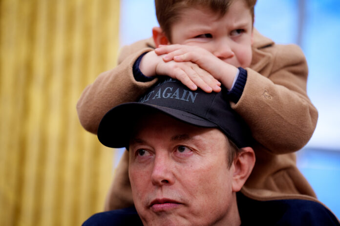 WASHINGTON, DC - FEBRUARY 11: X Musk sits on the shoulders of his father, Tesla and SpaceX CEO Elon Musk, as they join U.S. President Donald Trump for an executive order signing in the Oval Office at the White House on February 11, 2025 in Washington, DC. Trump is to sign an executive order implementing the Department of Government Efficiency's (DOGE) 