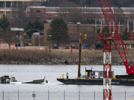 Rescue and salvage crews with cranes work near the wreckage of an American Airlines jet in the Potomac River from Ronald Reagan Washington National Airport, Sunday, Feb. 2, 2025, in Arlington, Va. (AP Photo/Jose Luis Magana)