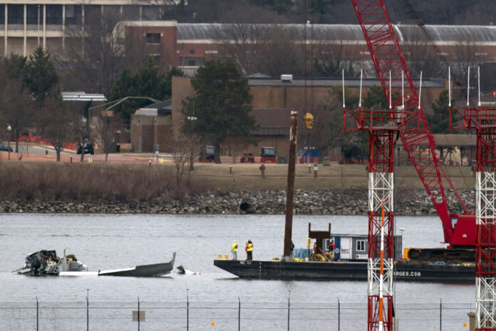 Rescue and salvage crews with cranes work near the wreckage of an American Airlines jet in the Potomac River from Ronald Reagan Washington National Airport, Sunday, Feb. 2, 2025, in Arlington, Va. (AP Photo/Jose Luis Magana)