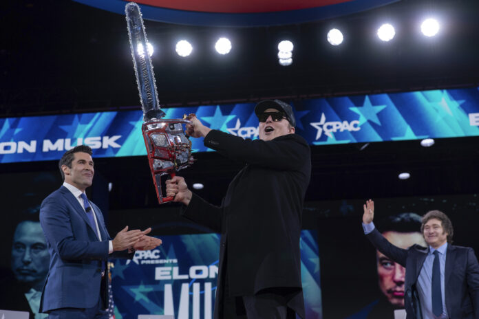 Elon Musk, left, receives a chainsaw from Argentina's President Javier Milei, right, as they arrive speaks at the Conservative Political Action Conference, CPAC, at the Gaylord National Resort & Convention Center, Thursday, Feb. 20, 2025, in Oxon Hill, Md. (AP Photo/Jose Luis Magana)