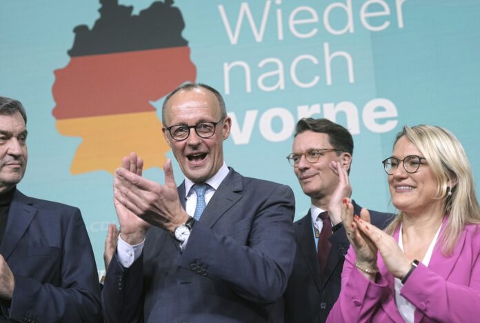 Friedrich Merz, second left, leader of the Christian Democratic Union (CDU), applauds while addressing supporters at the party headquarters in Berlin, Germany, Sunday, Feb. 23, 2025, after the German national election. (Michael Kappeler/dpa via AP)