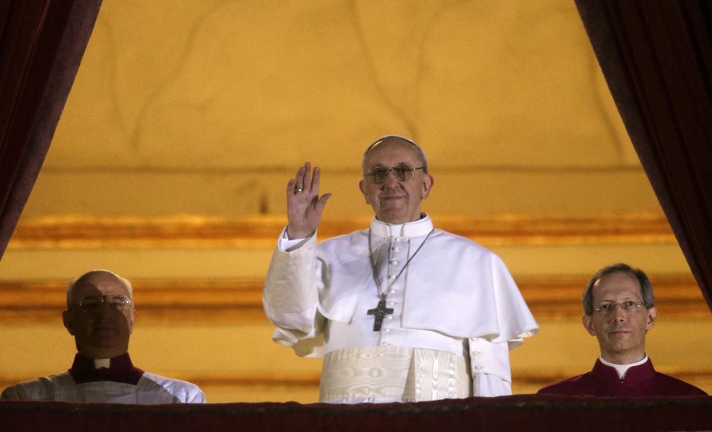 Pope Francis waves to the crowd as he appears at the central balcony of St. Peter's Basilica at The Vatican minutes after his election, March 13, 2013. (AP Photo/Gregorio Borgia, File)