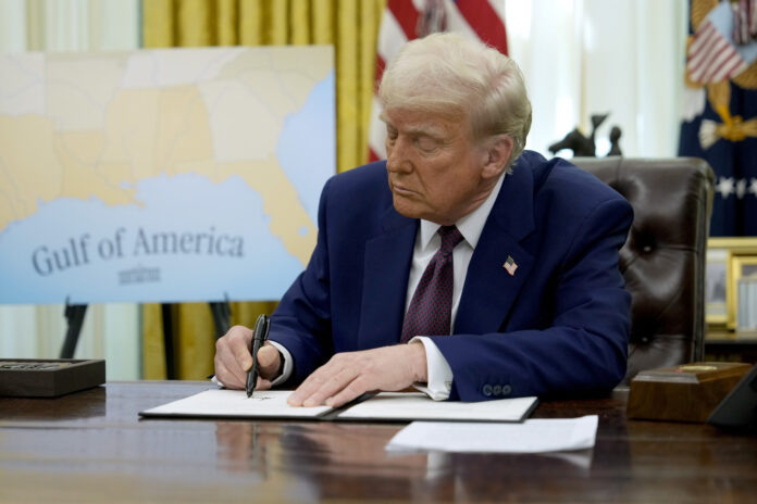 President Donald Trump signs an executive order in the Oval Office of the White House, Thursday, Feb. 13, 2025, in Washington. (AP Photo/Ben Curtis)