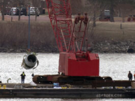 Rescue and salvage crews pull up a plane engine as cranes work near the wreckage of an American Airlines jet in the Potomac river from Ronald Reagan Washington National Airport, Monday, Feb. 3, 2025, in Arlington, Va. (AP Photo/Jose Luis Magana)