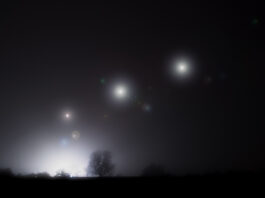 Glowing alien UFO lights floating in the sky. On a spooky foggy winters night