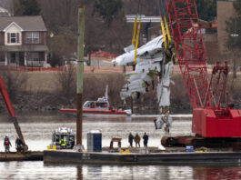 Rescue and salvage crews with cranes pull up the wreckage of an American Airlines jet in the Potomac River from Ronald Reagan Washington National Airport, Monday, Feb. 3, 2025, in Arlington, Va. (AP Photo/Jose Luis Magana)