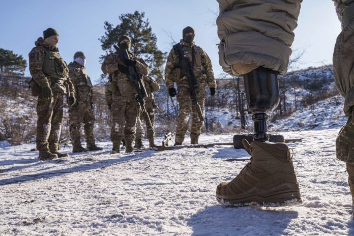 Serhii Pozniak, a sniper unit commander with the 27th national guard brigade, speaks to soldiers during military training near Kyiv, Ukraine, on Feb. 17, 2025. (AP Photo/Evgeniy Maloletka)