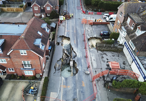 A sinkhole appears on a principal road in a British village