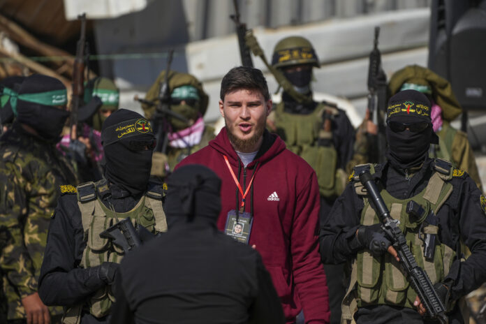 Alexander Troufanov, 29, who holds Israeli and Russian citizenship, is escorted by Hamas and islamic Jihad fighters as he is handed over to the Red Cross in Khan Younis, Gaza Strip, Saturday, Feb. 15, 2025. (AP Photo/Abdel Kareem Hana)