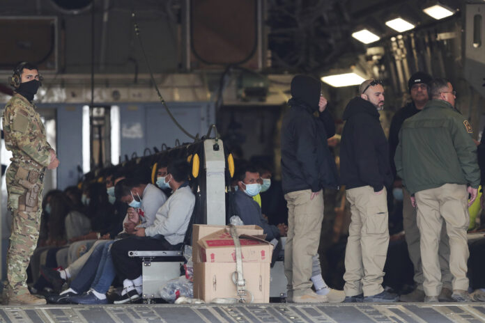 Migrants sit on a military aircraft at Fort Bliss in El Paso, Tx., Thursday, Jan. 30, 2025, awaiting their deportation to Guatemala. (AP Photo/Christian Chavez)