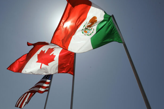 FILE - National flags representing the United States, Canada, and Mexico fly in the breeze in New Orleans where leaders of the North American Free Trade Agreement met on April 21, 2008. (AP Photo/Judi Bottoni, File)