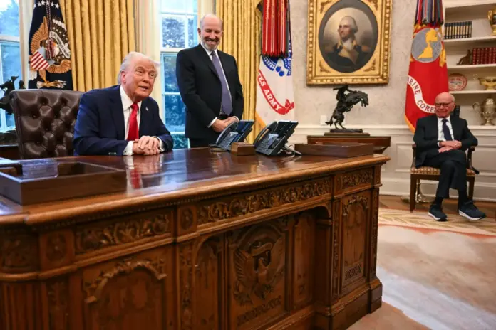 Donald Trump, alongside Secretary of Commerce nominee Howard Lutnick (center) and Rupert Murdoch (right), speaks to the press after signing an executive order to create a US sovereign wealth fund, in the Oval Office of the White House on Monday. AFP via Getty Images