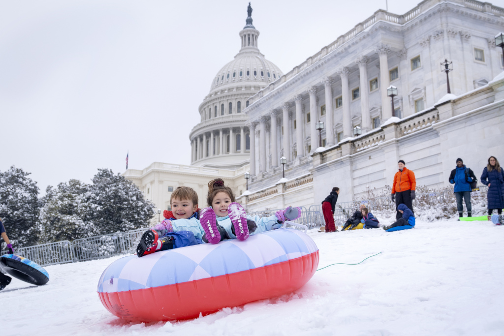 James Prince, 4, and Olivia Averyt, 4, sled down a hill at the Capitol, Wednesday, Feb. 12, 2025, after a snowstorm in Washington. (AP Photo/Jacquelyn Martin)