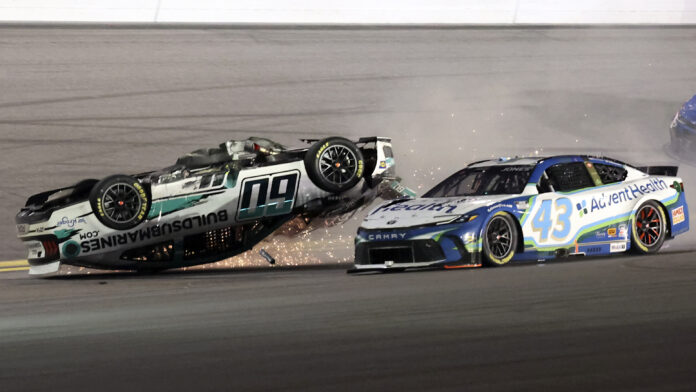 Ryan Preece (60) flips upside down as he crashes going in to turn 3 as Erik Jones (43) goes past during the NASCAR Daytona 500 auto race at Daytona International Speedway, Sunday, Feb. 16, 2025, in Daytona Beach, Fla. (AP Photo/Mike Troxell)