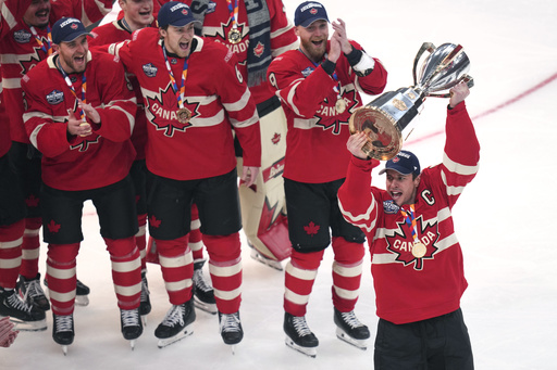 Canada captain Sidney Crosby, right, hoists the trophy after defeating the United States following an overtime period of the 4 Nations Face-Off championship hockey game, Thursday, Feb. 20, 2025, in Boston. (AP Photo/Charles Krupa)